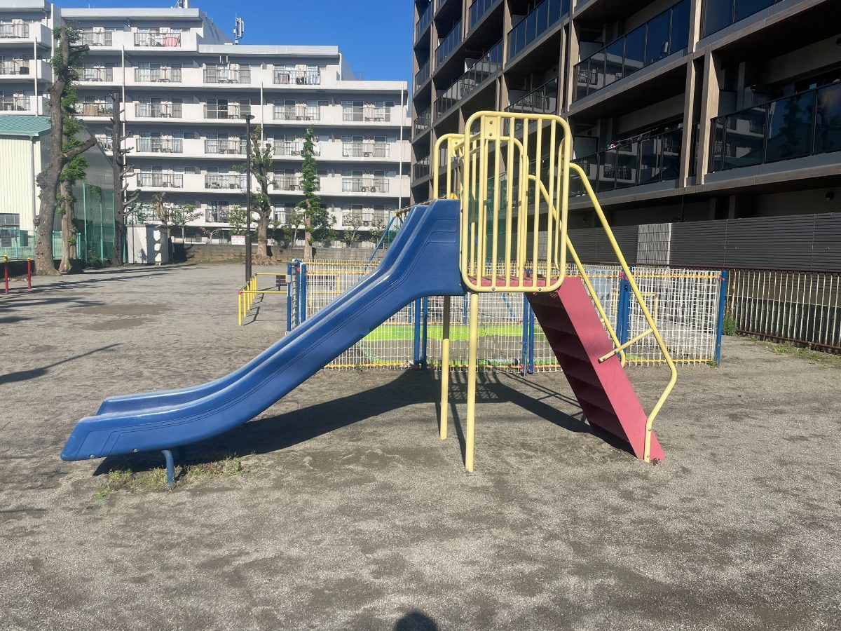 本町4丁目児童遊園地のすべり台。青い滑り台と黄色・赤のフレームの遊具